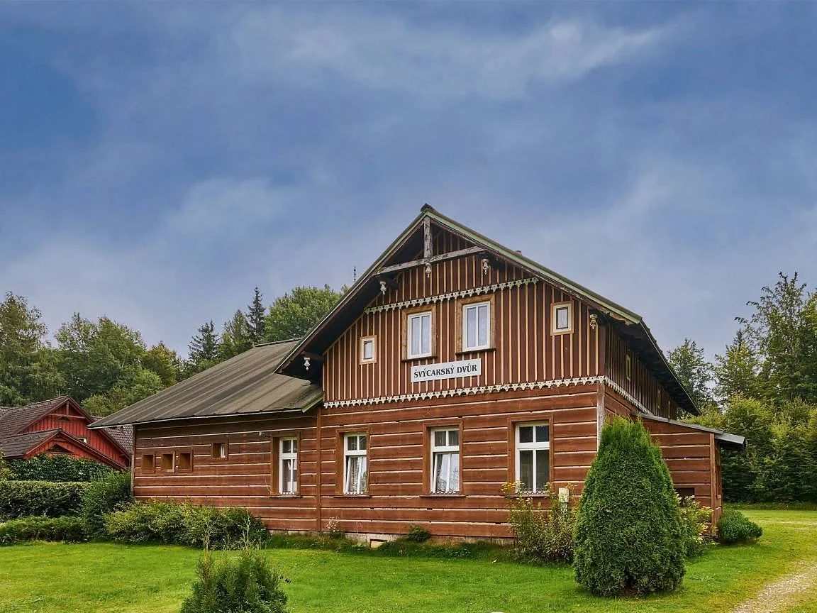 Roubená chata Švýcarský dvůr s ozdobným štítem v létě